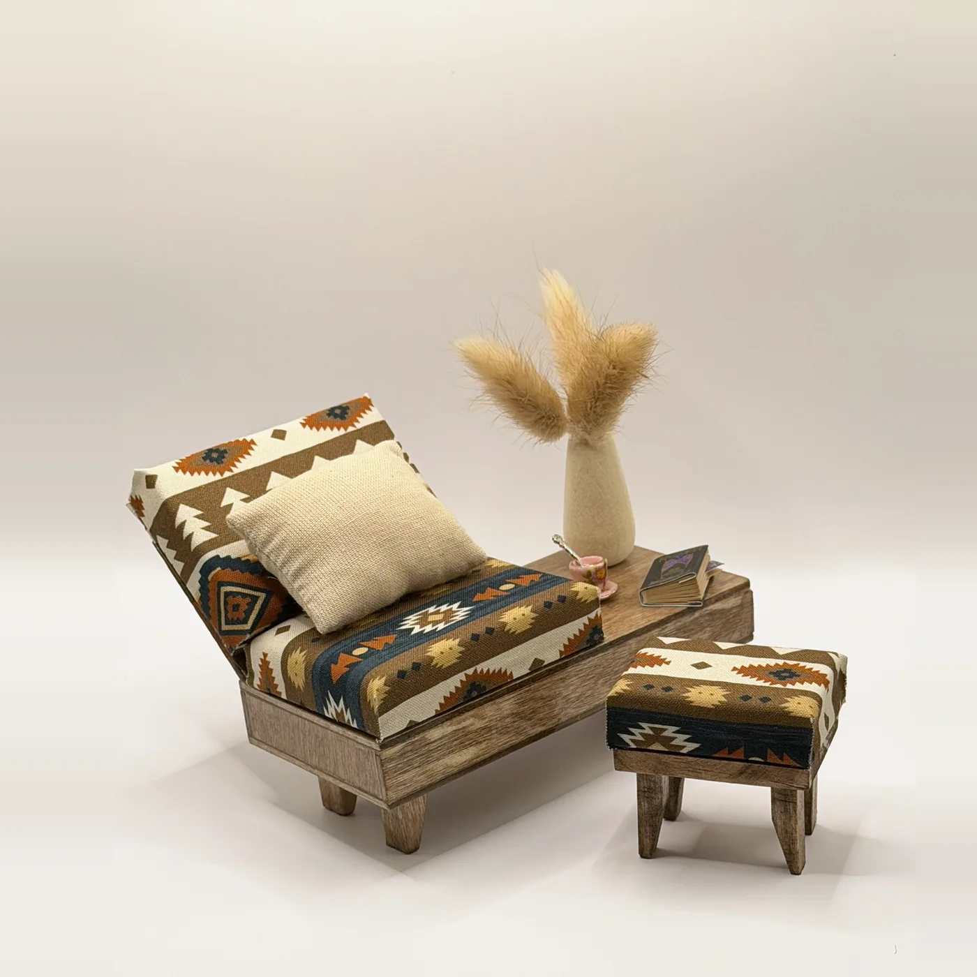 The Santa Fe Lounge Set styled with a vase of pampas grass, a tiny cup, and a book on its built-in side table.
