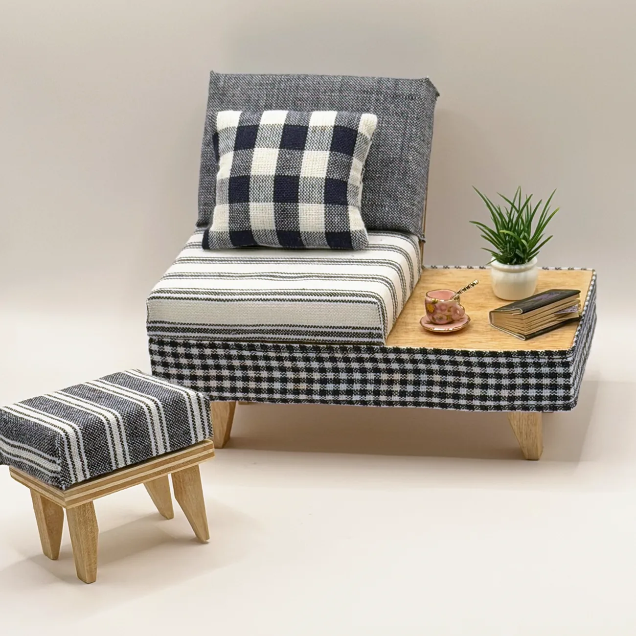 The Sunday Lounge Set, a miniature seat in charcoal-and-cream stripes and gingham with a textured gray backrest, built-in side table, and matching striped ottoman.